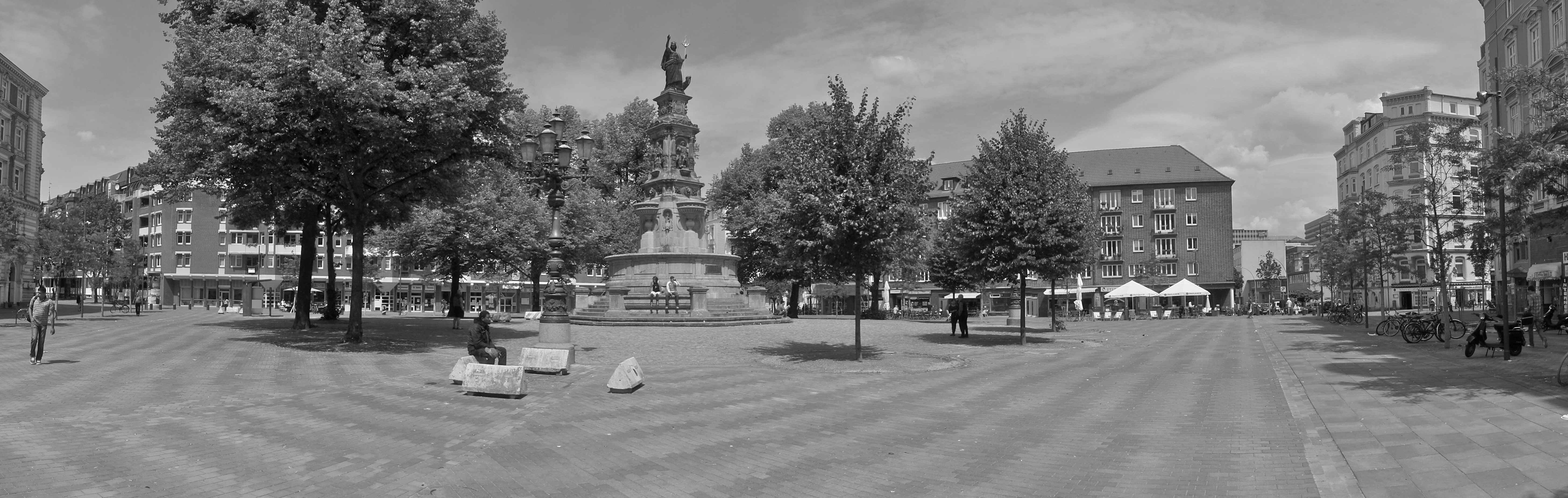 Schwarz-weiß Bild eines Parks mit einer großes Statue (Hansaplatz)